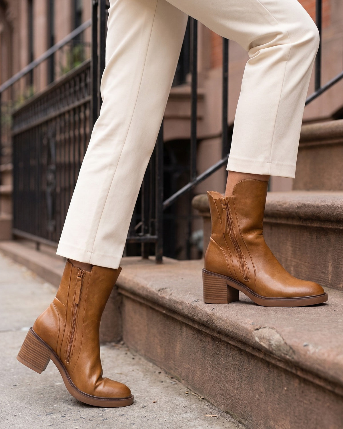 Hazel cognac ankle boots worn with cream trousers on brownstone steps