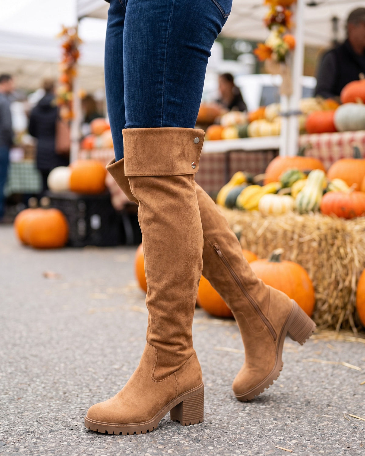 Mira tan tall boots worn with jeans at an autumn market