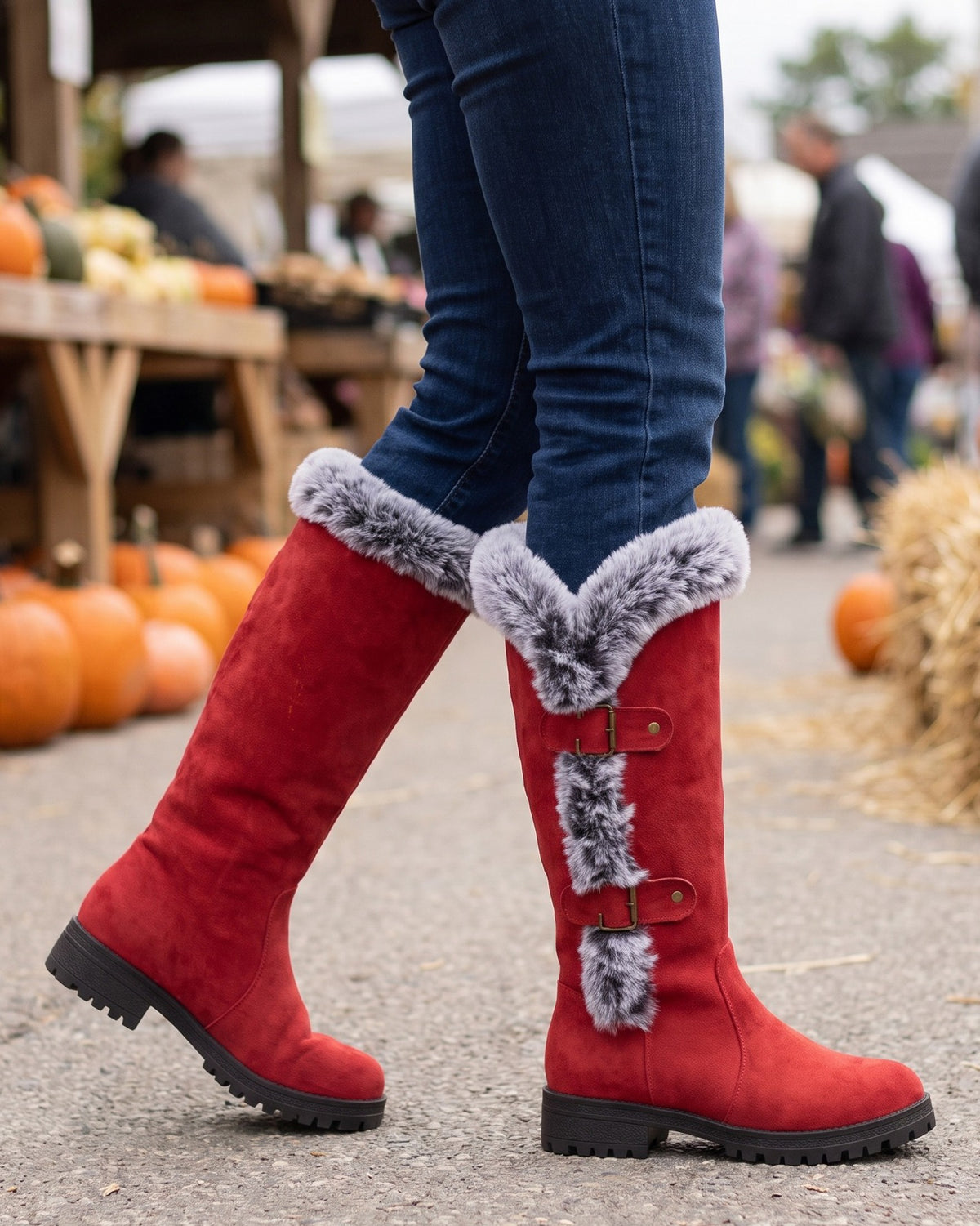 Beatrix red tall boots worn with jeans at an autumn market