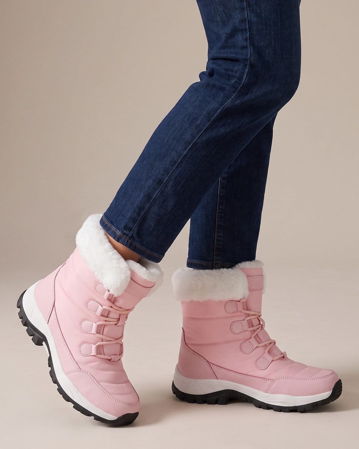 Birdie pink snow boots worn with jeans, studio shot of legs