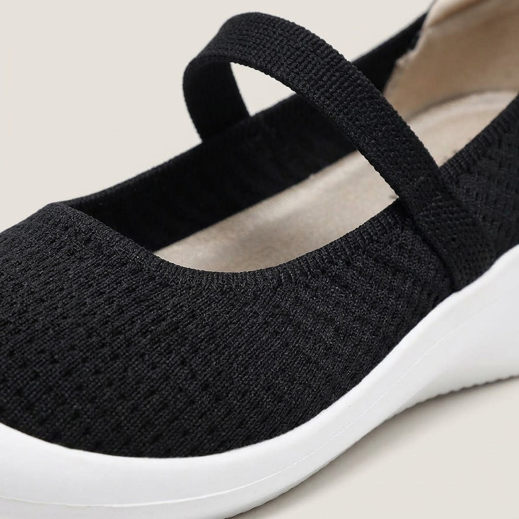 Close-up of the knit upper, elastic strap and white sole on the Faye shoe