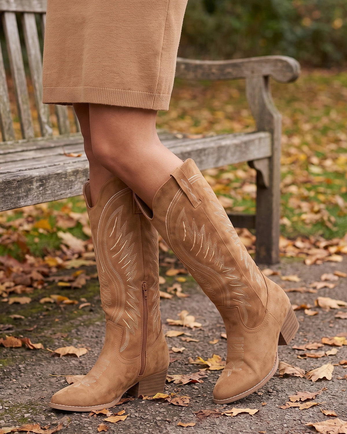 Imogen tan western boots worn with a camel skirt by a park bench in autumn