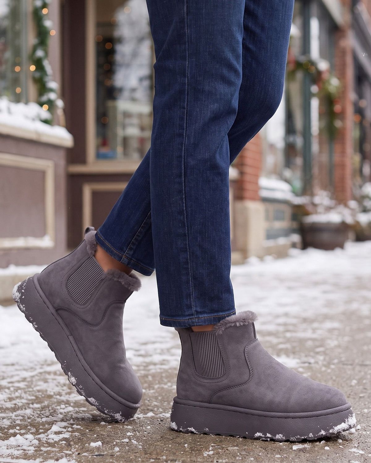 Ivy grey chelsea boots worn with jeans on a snowy town sidewalk