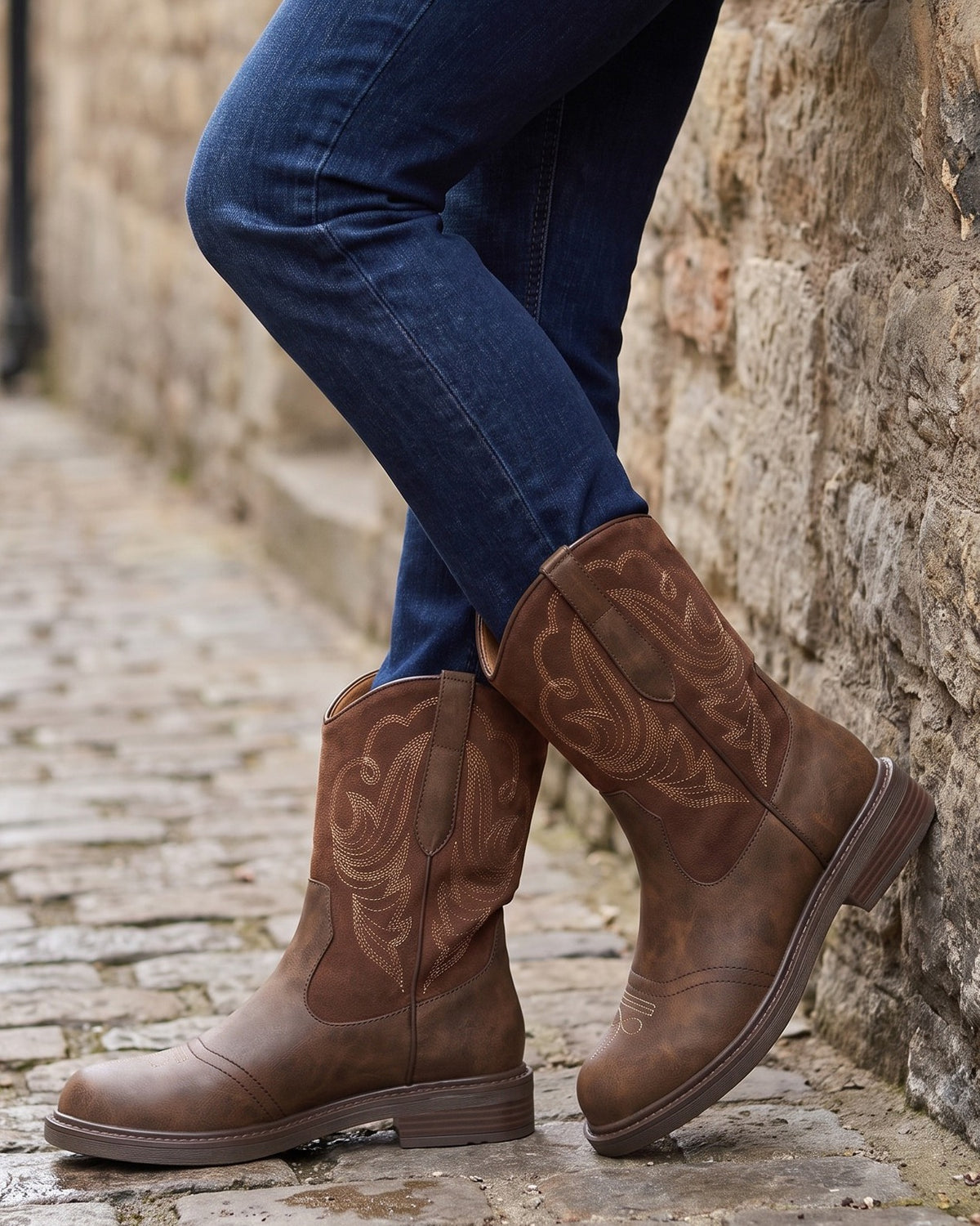 Juliet brown western boots worn with jeans on a cobblestone lane