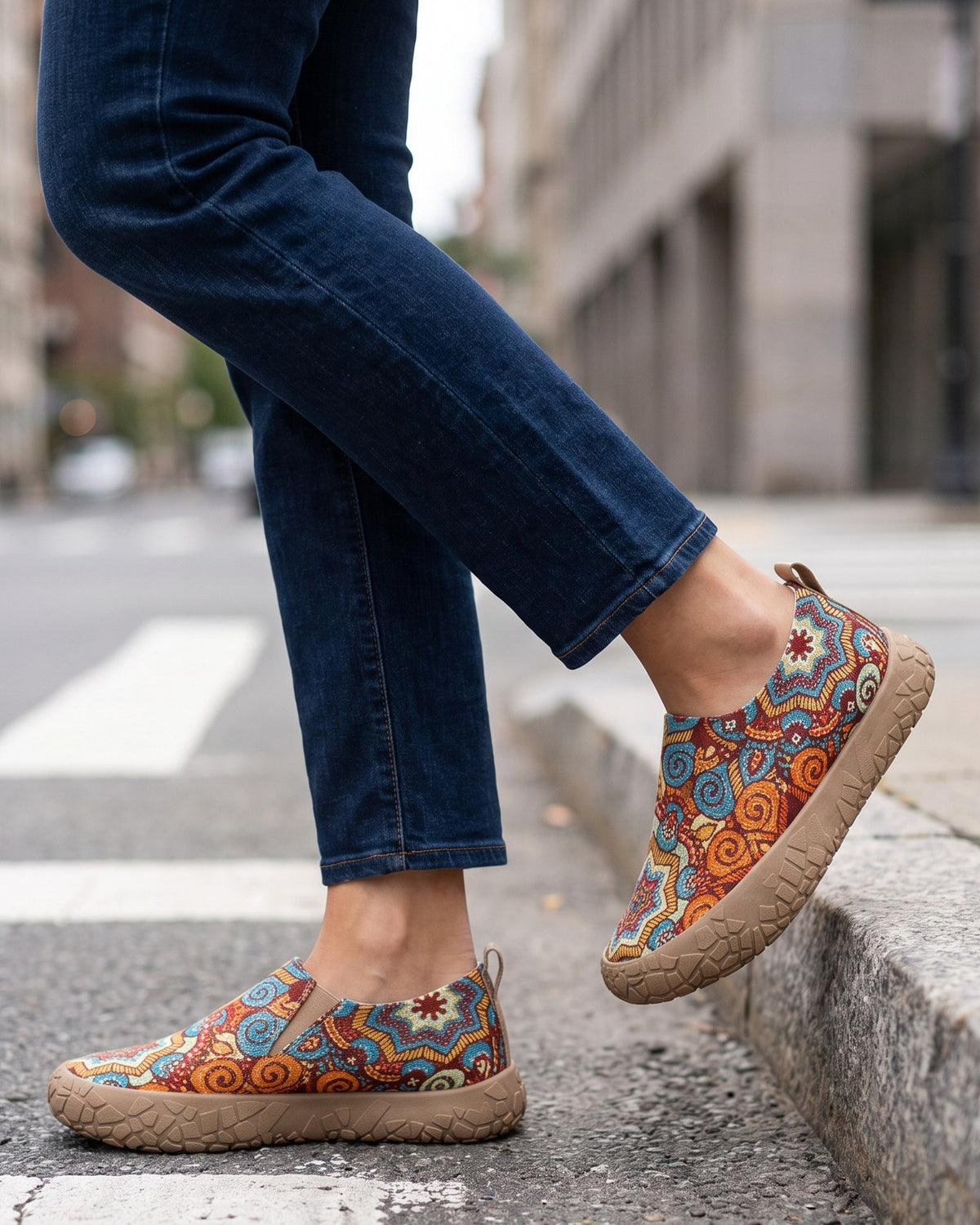 Juniper paisley slip-ons worn with jeans at a city crosswalk