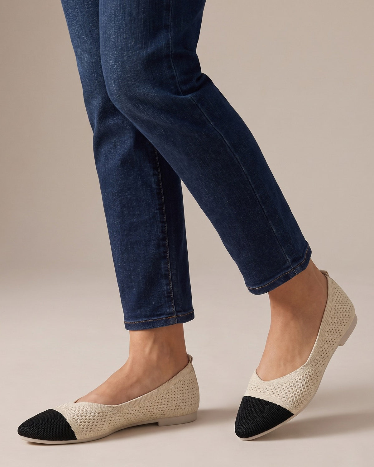 Lottie two-tone pointed flats worn with jeans, studio shot of legs