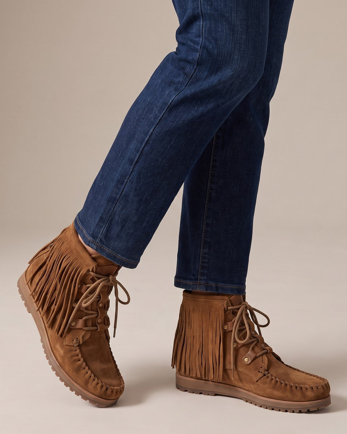 Marlowe fringe moccasin boots worn with jeans, studio shot of legs