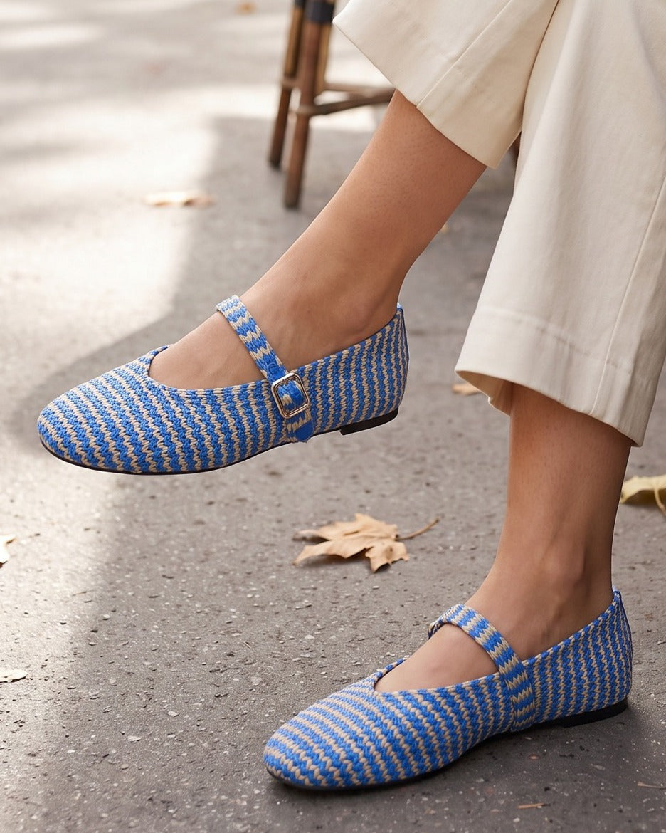 Poppy striped Mary Janes worn with cream trousers at a sidewalk café