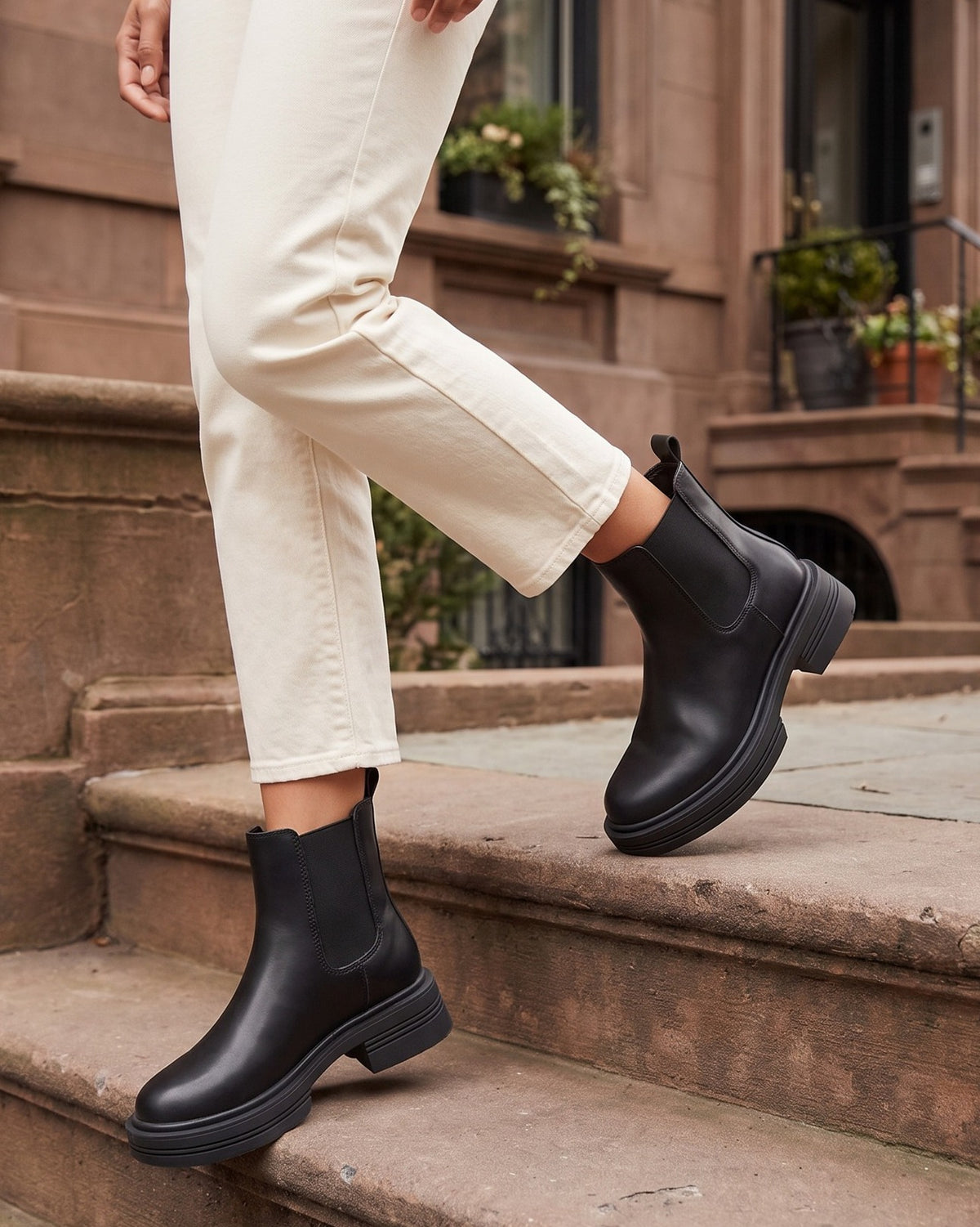 Quinn black chelsea boots worn with cream trousers on brownstone steps