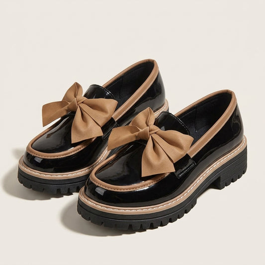 Rosalie black glossy platform loafers with tan bow and tan trim, pair