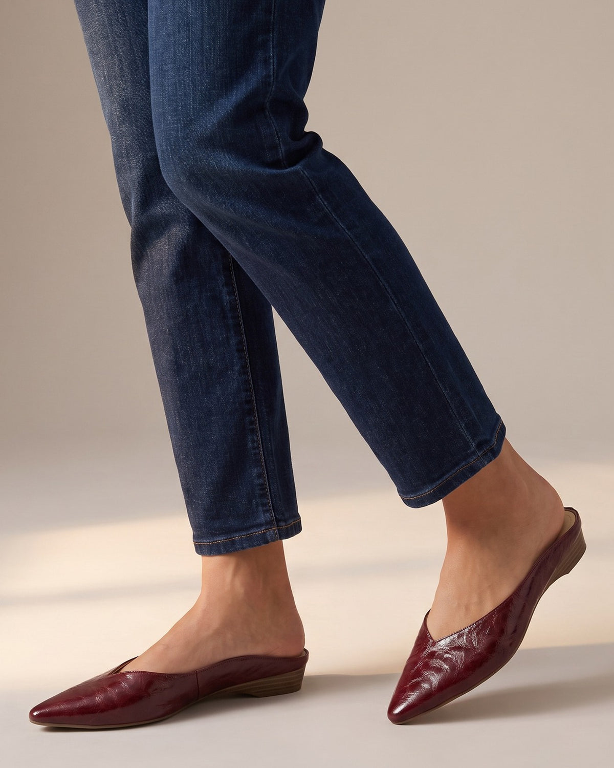 Thea burgundy mules worn with jeans, studio shot of legs