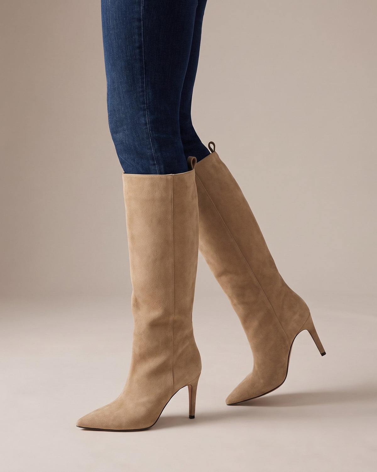 Vera beige knee-high boots worn with jeans, studio shot of legs