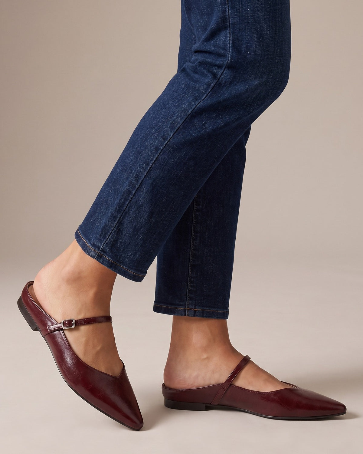Verity wine-red mules worn with jeans, studio shot of legs