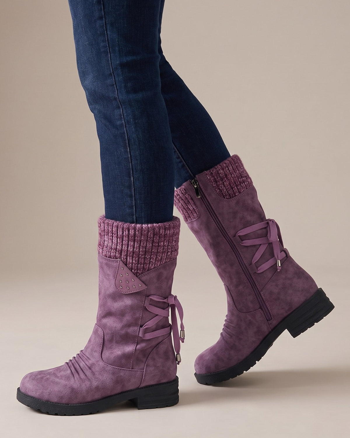 Violet purple boots worn with jeans, studio shot of legs