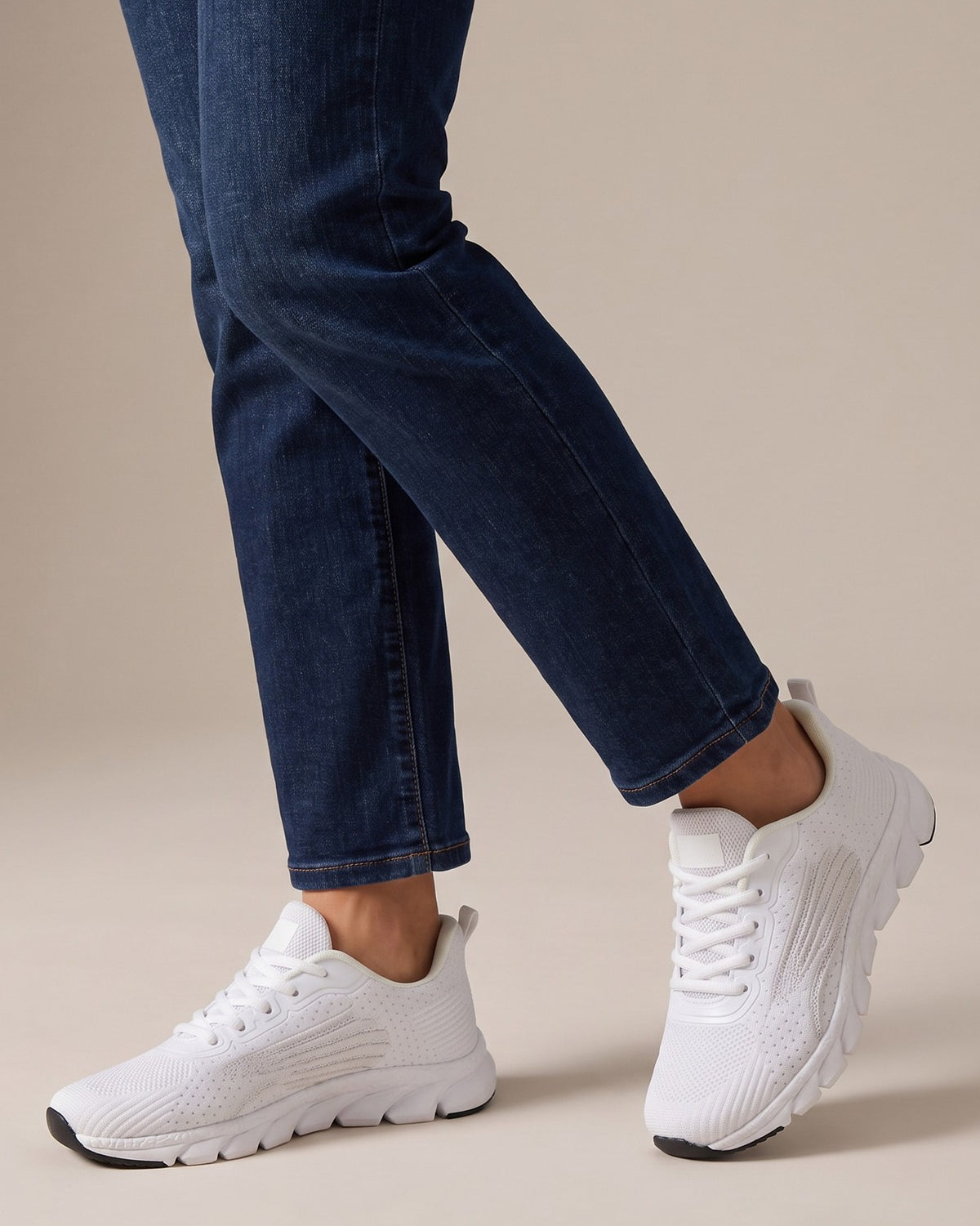 Wren white knit sneakers worn with jeans, studio shot of legs